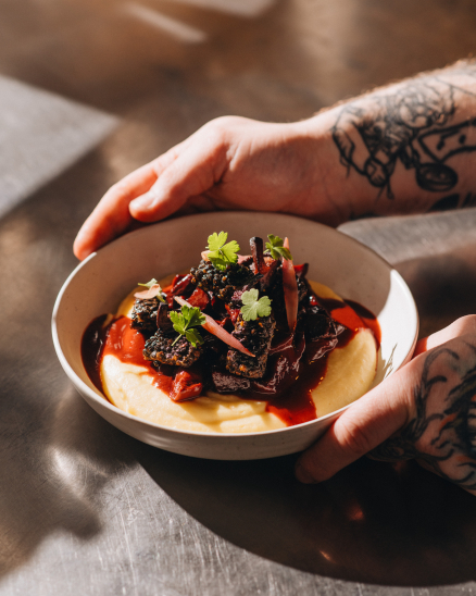 Silný bourguignon z kořenové zeleniny, tuřínová kaše, pošírovaná šalotka, tempeh z černé čočky